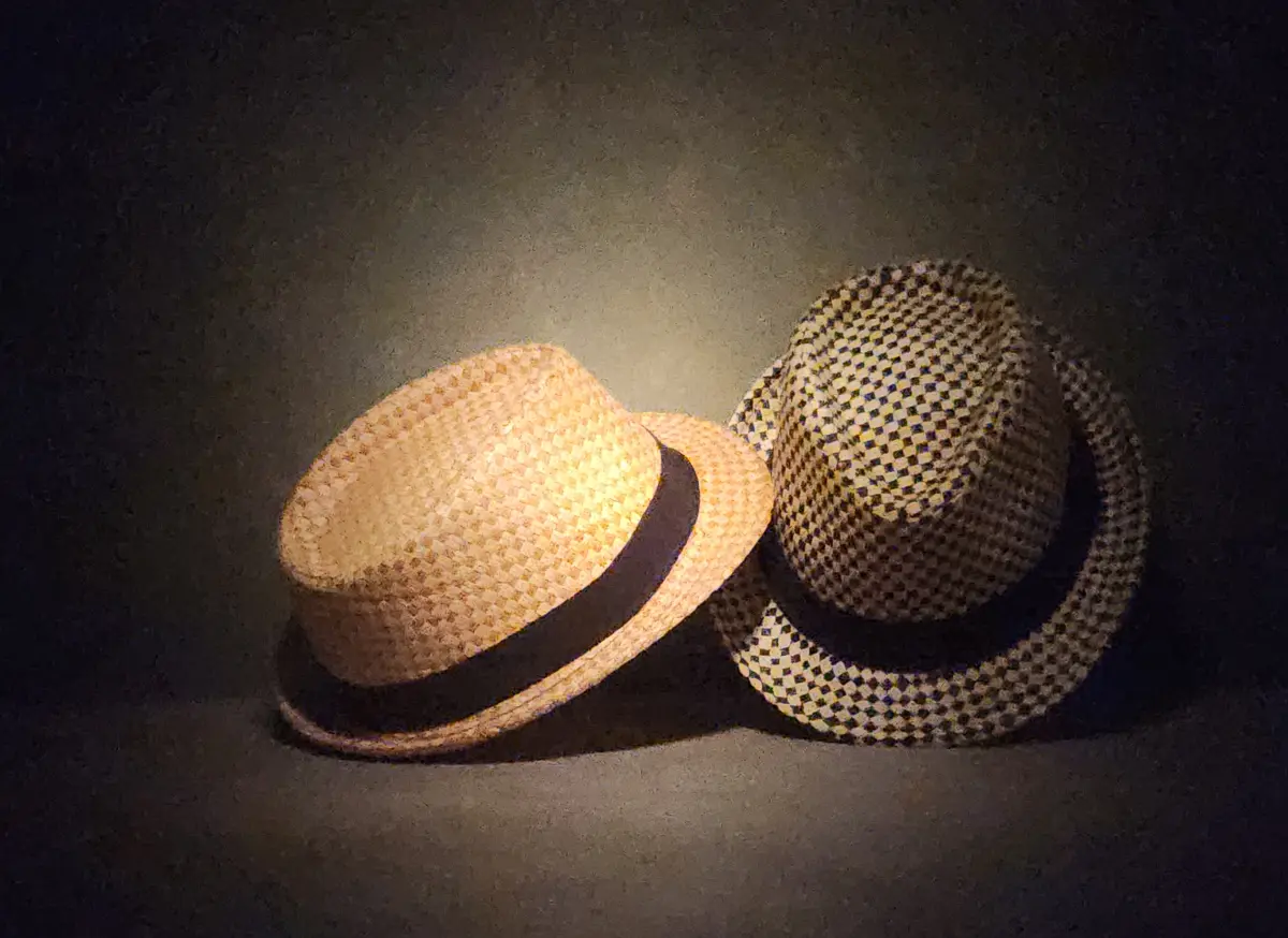 dagrosa-the-hats-the-mask-of-identity Two fedora-style hats photographed in dramatic lighting, representing identity and personal presence